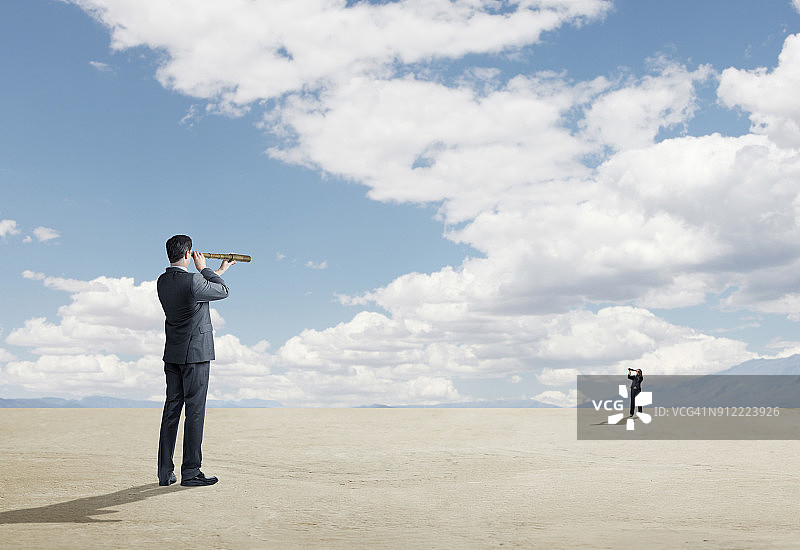 两人通过望远镜互相看向图片素材