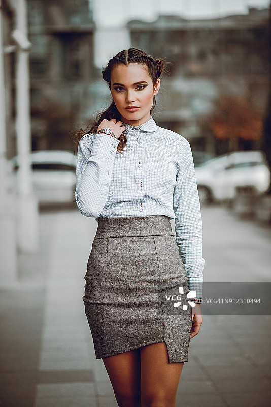 在城市街道行走和摆姿势的现代商务女性图片素材