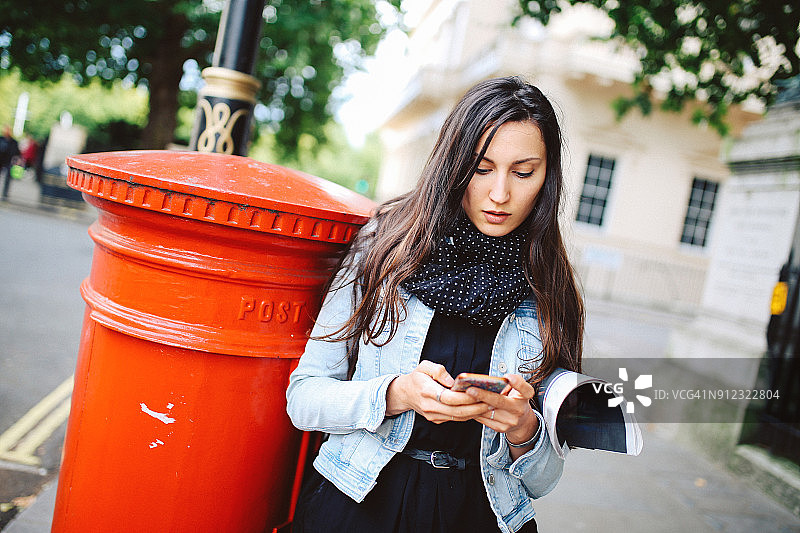 年轻女人在英国伦敦街头用手机发短信图片素材
