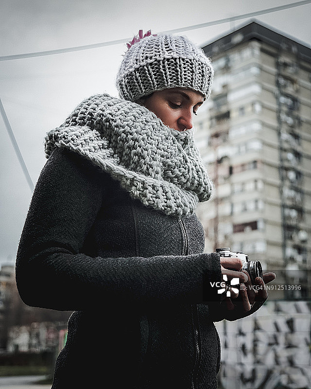 拿着旧式测距相机的美丽女人图片素材