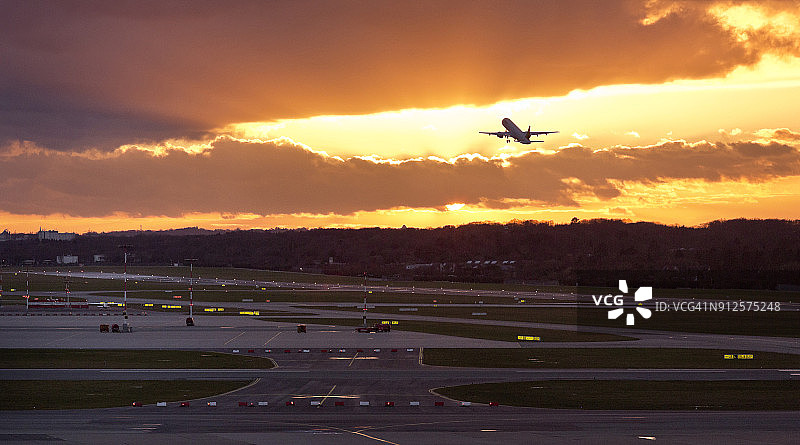 日落时分，飞机在德国汉堡机场起飞图片素材