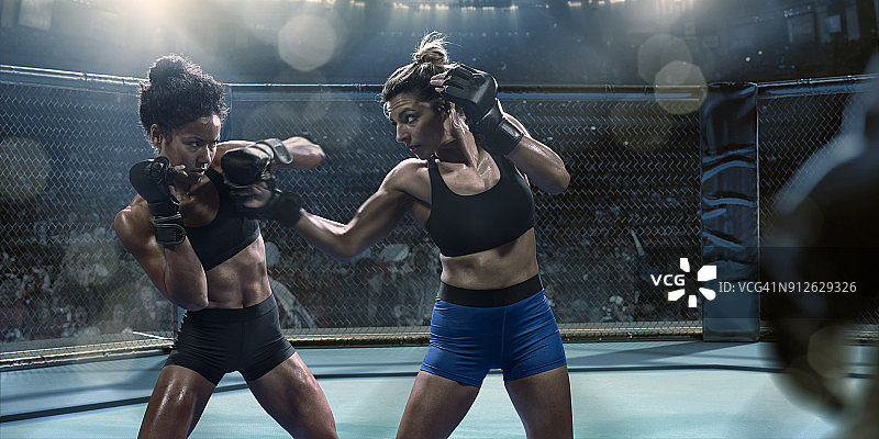 八角笼中挥拳的职业女子综合格斗选手图片素材