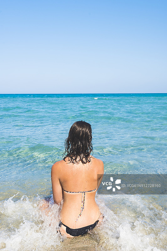 年轻女人坐在海边图片素材