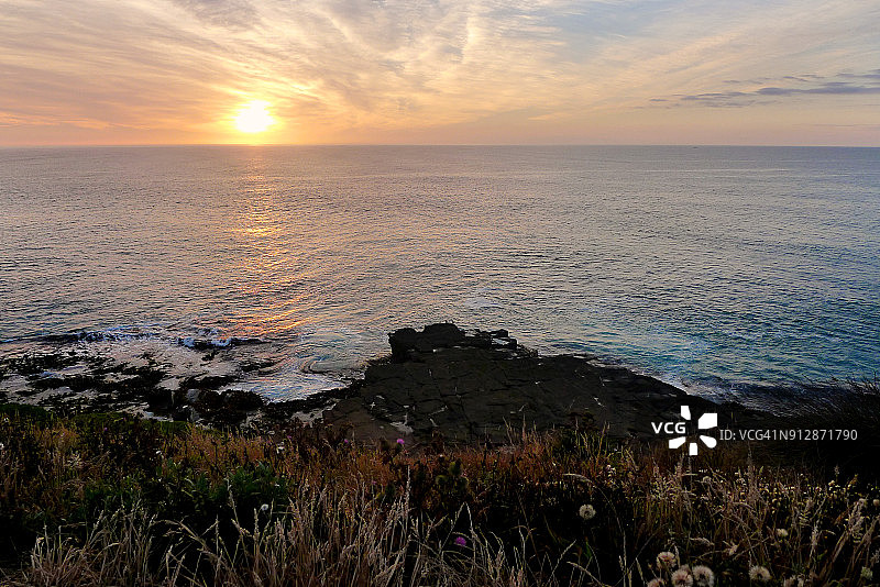 库里奥湾日出景色：海浪拍打悬崖岩石图片素材