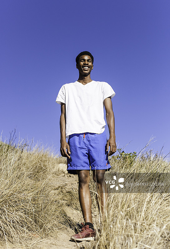 在山上露出灿烂笑容的年轻男人图片素材