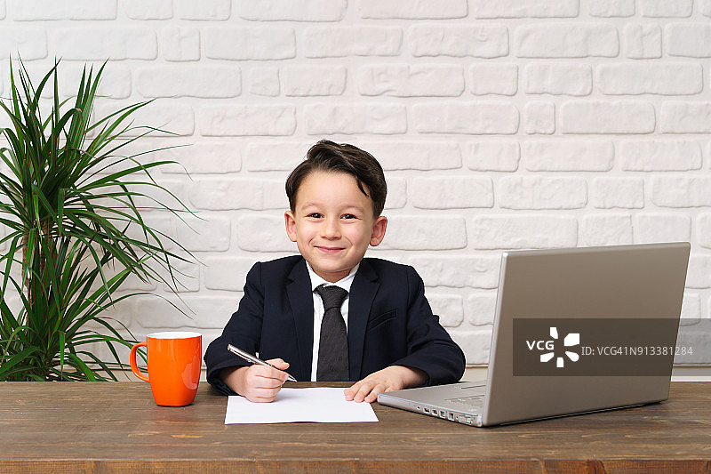 穿着西装在办公室工作的儿童图片素材
