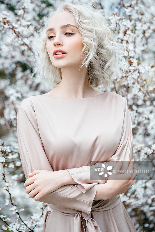 春天灌木丛背景上的美丽女孩图片素材