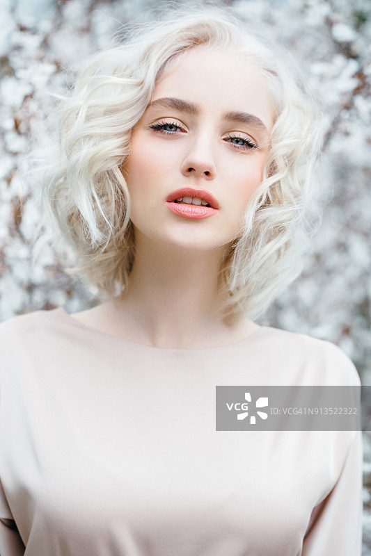 春天灌木丛背景上的美丽女孩图片素材