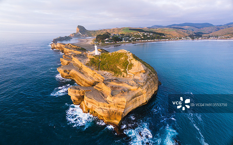 日出时分，城堡角灯塔与村庄全景图片素材