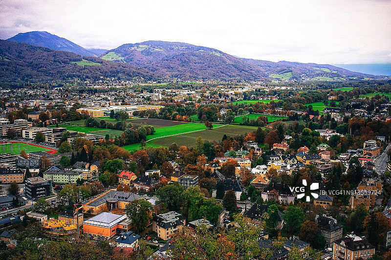 秋季奥地利萨尔茨堡，从霍亨萨尔茨堡要塞屋顶俯瞰绿色田野中的房屋图片素材