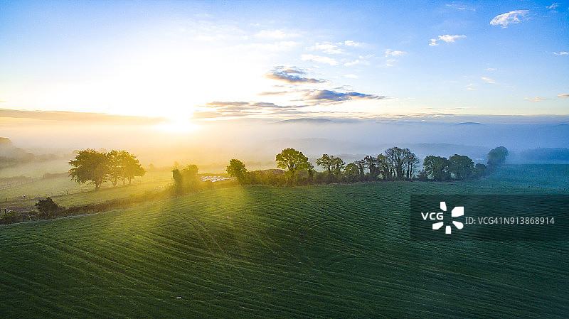 蒂珀雷里群山上雾天的彩色日出图片素材