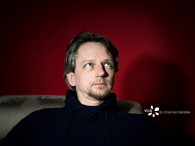 红色背景上的中年男人工作室肖像图片素材