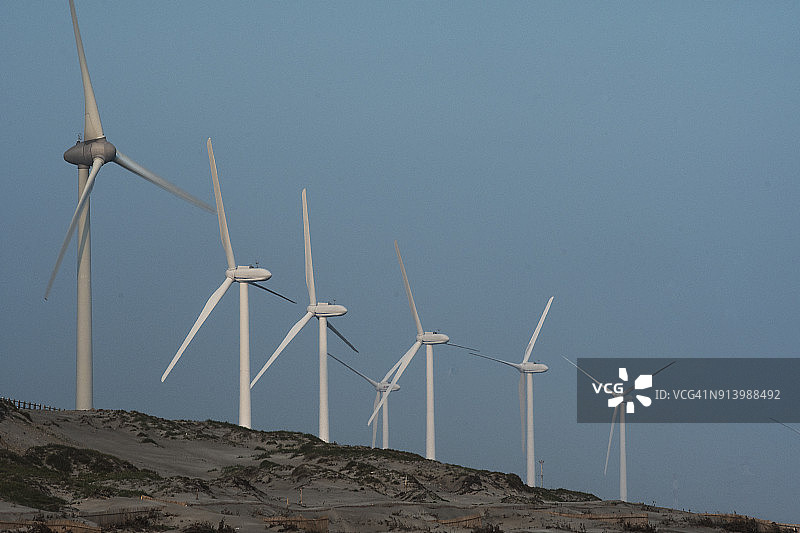 山坡上一排风力发电机图片素材