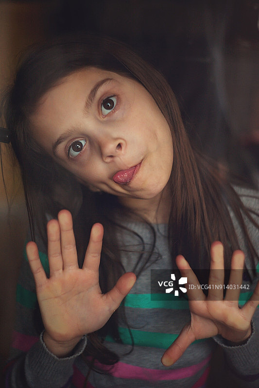 女孩隔着窗户做鬼脸图片素材