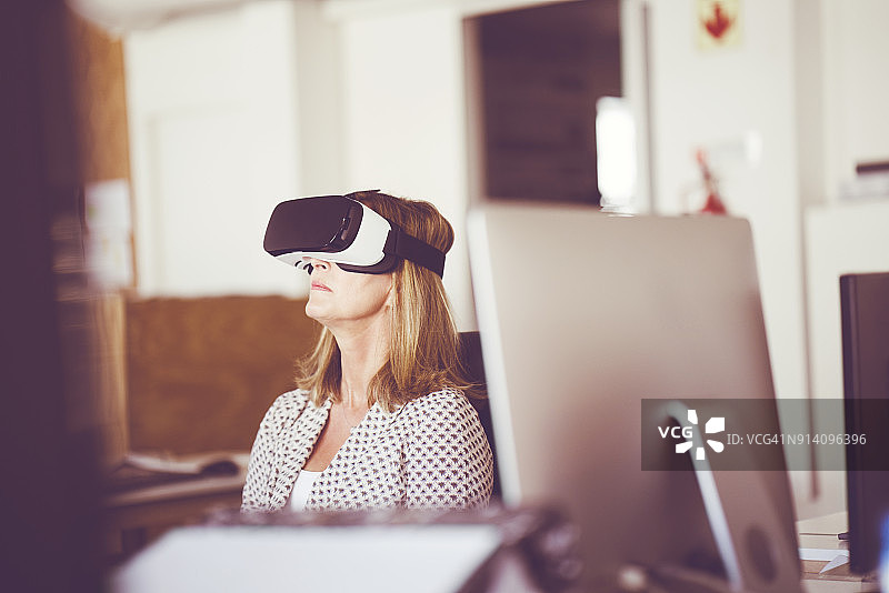 在办公室佩戴VR眼镜的专业人士图片素材