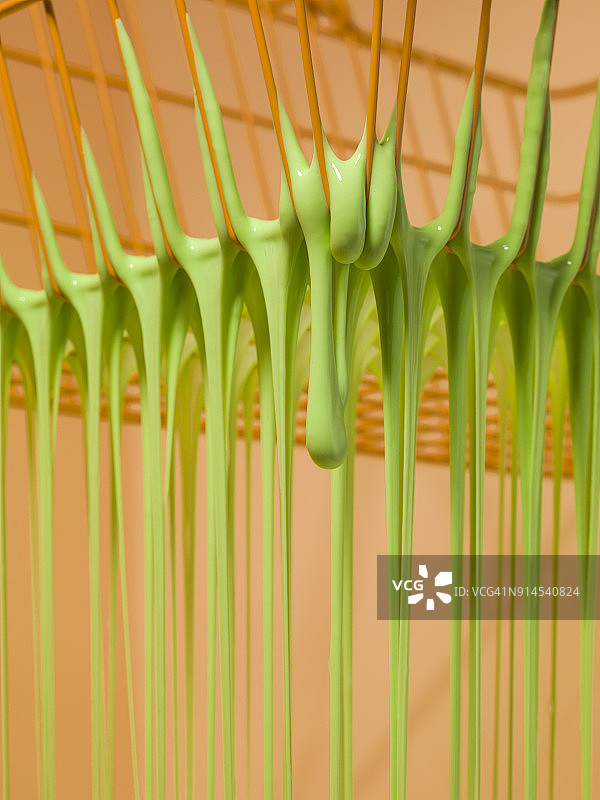 从金属购物篮的孔中滴落的粘液图片素材