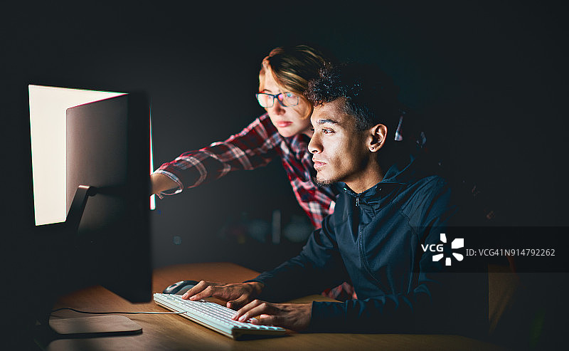 深夜用电脑工作的两个年轻人图片素材