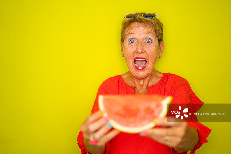 时尚老年人的色彩潮流 - 准备吃西瓜的健康老年妇女图片素材