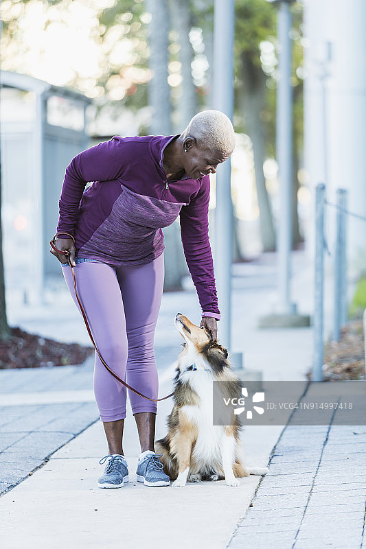 年长的非裔美国妇女在遛狗图片素材