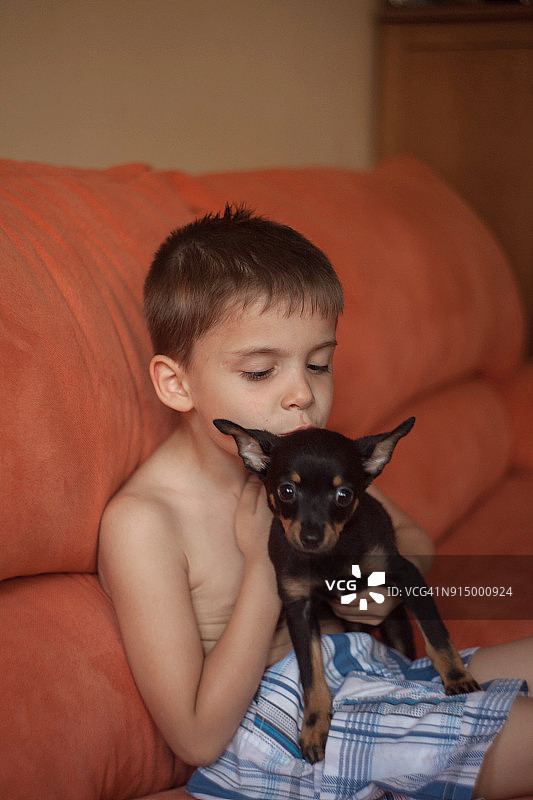 可爱的白人小男孩和他的小狗拥抱图片素材