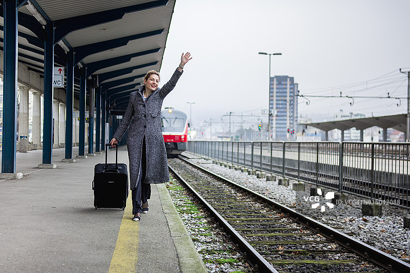 女人在火车站向火车挥手图片素材