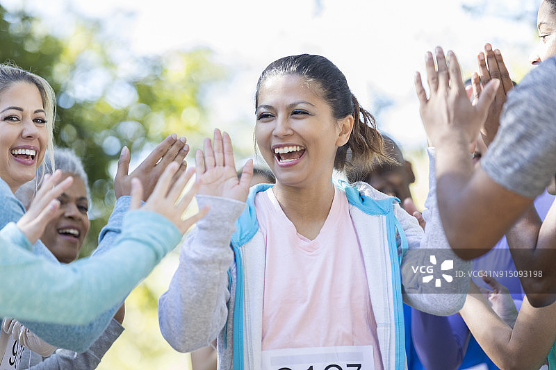 完成慈善赛跑后，女人与他人击掌庆祝图片素材