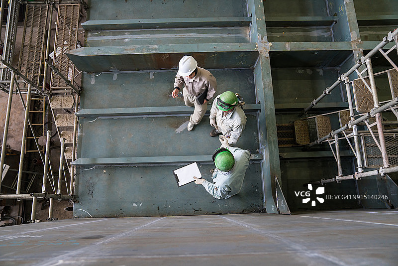 工程师讨论造船项目进度俯视图图片素材