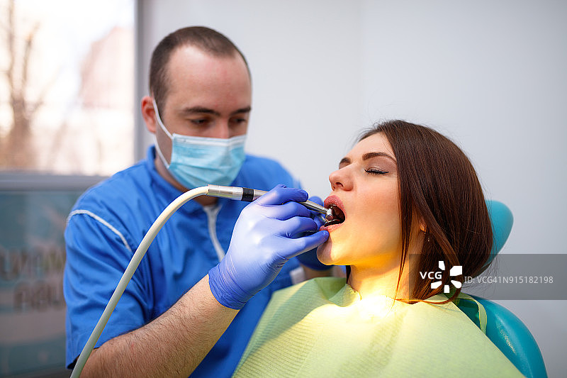 年轻女人在牙医诊所接受治疗图片素材