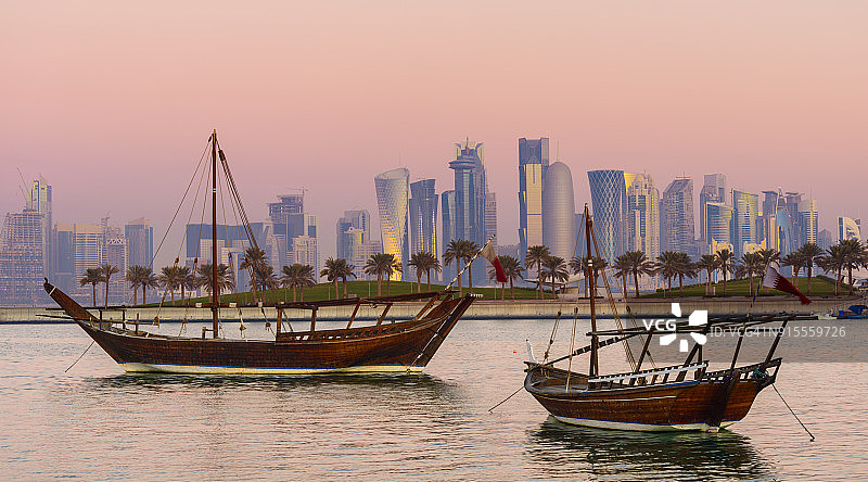 卡塔尔多哈市中心天际线和传统三角帆船日落景观图片素材