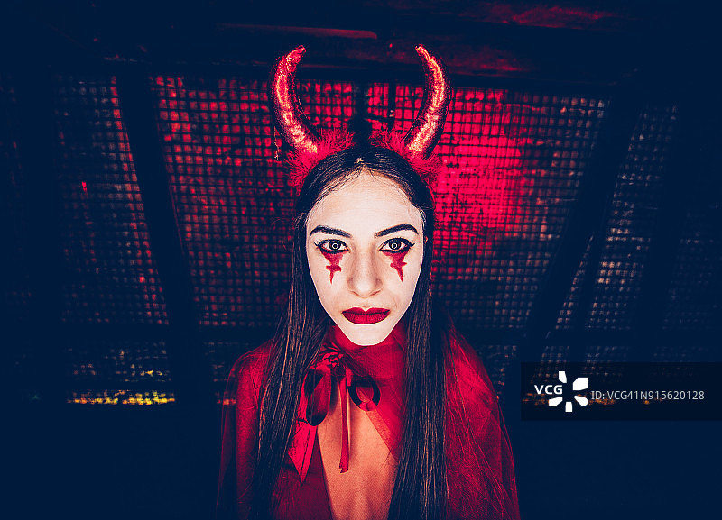 万圣节身穿红色恶魔服装并化着夸张妆容的女子图片素材