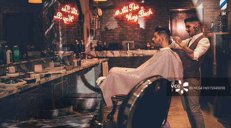 在复古理发店理发的时尚男人图片素材