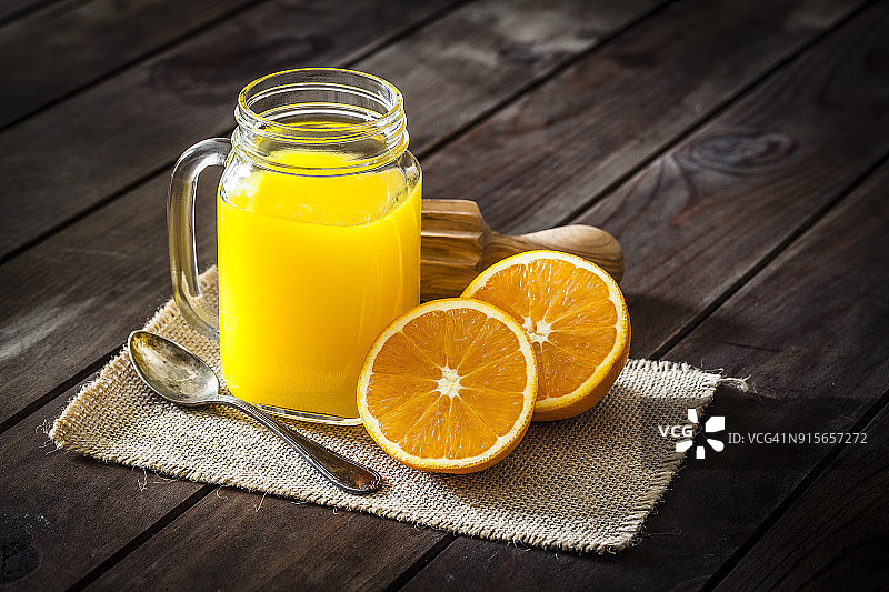 乡村木桌上的橙汁玻璃罐图片素材