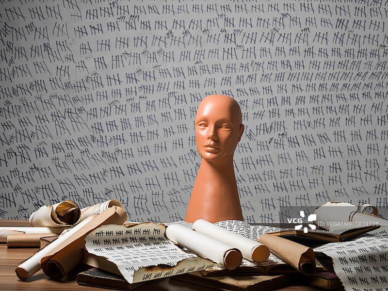 塑料人体模型头部和书桌上的古董书籍图片素材