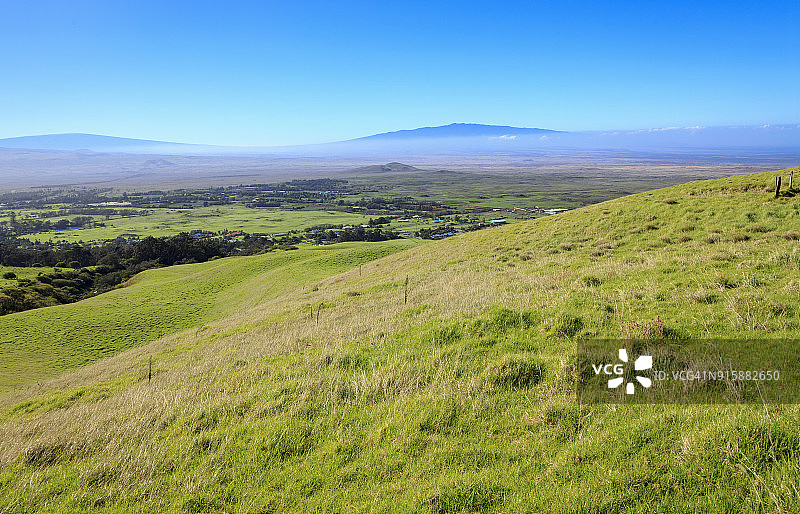 夏威夷卡姆埃拉上方的牧场，可欣赏冒纳罗亚火山和呼阿拉莱火山的景色图片素材