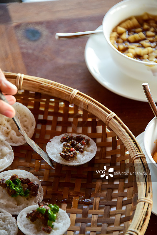 用铲子将越南香兰米糕从烤模中取出，放在棕榈叶编织的托盘上图片素材