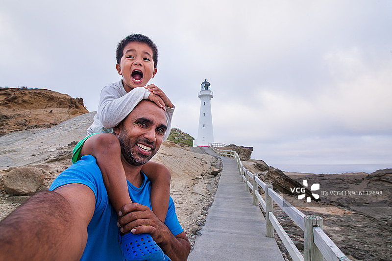父子在卡斯尔波因特灯塔前自拍图片素材