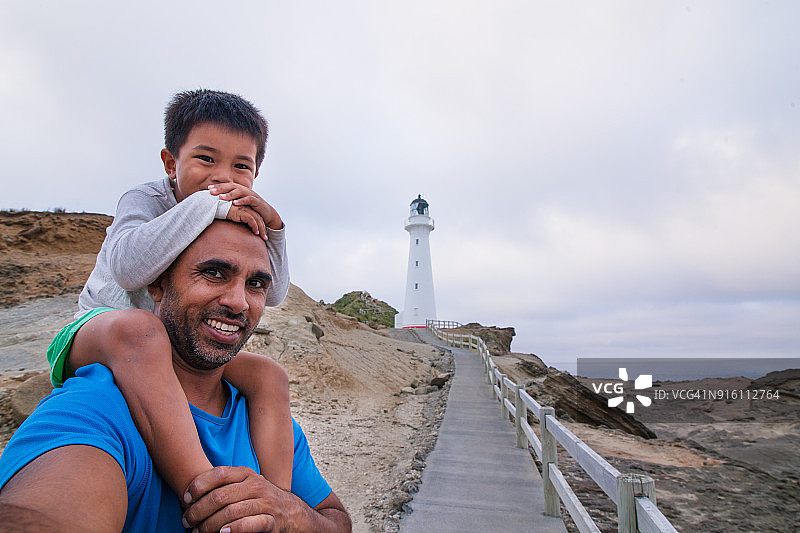 父子在卡斯尔波因特灯塔前自拍图片素材