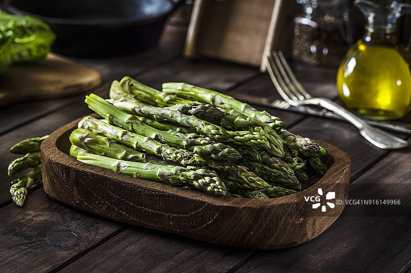 质朴木桌上的新鲜有机芦笋图片素材