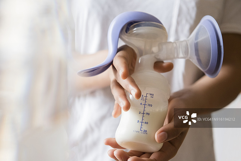 用吸奶器吸母乳的非裔美国妇女图片素材