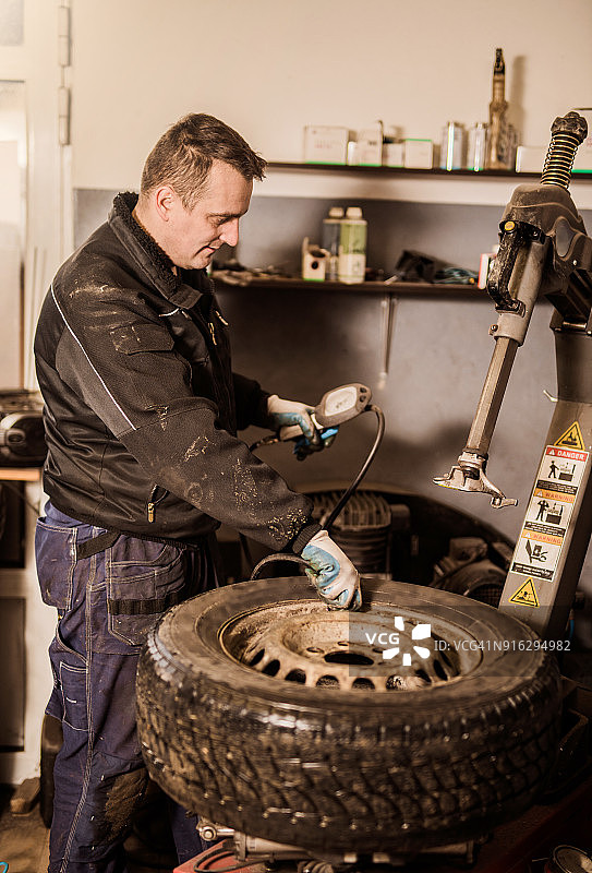 技工给瘪轮胎充气图片素材