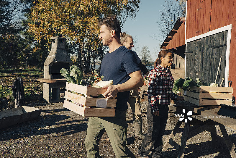 中年男子在农贸市场搬运装满蔬菜的板条箱图片素材