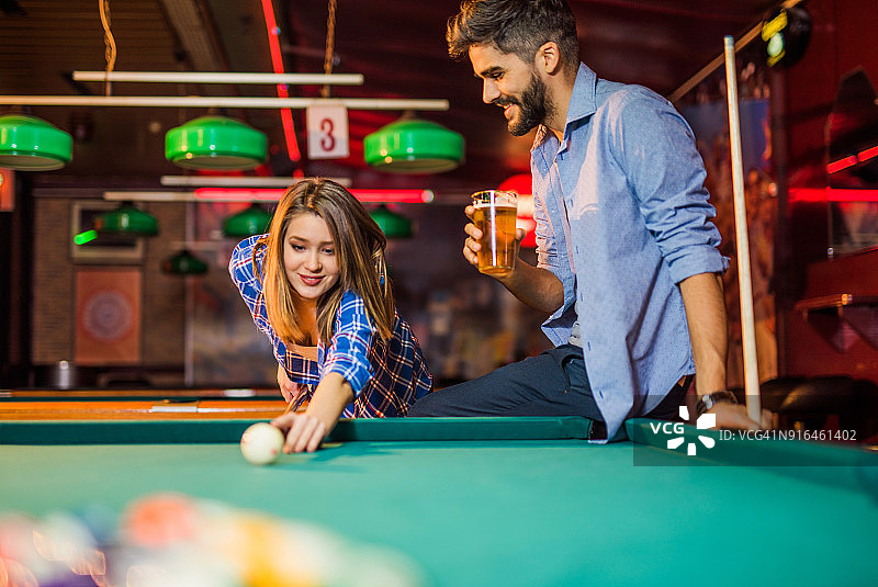 幸福的年轻夫妇在酒吧一起打台球图片素材