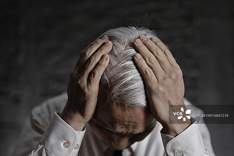 中年男人痛苦地抱着头图片素材
