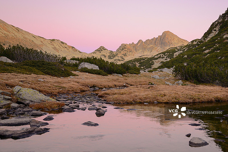 夕阳映照下的皮林山峰倒影在河中图片素材