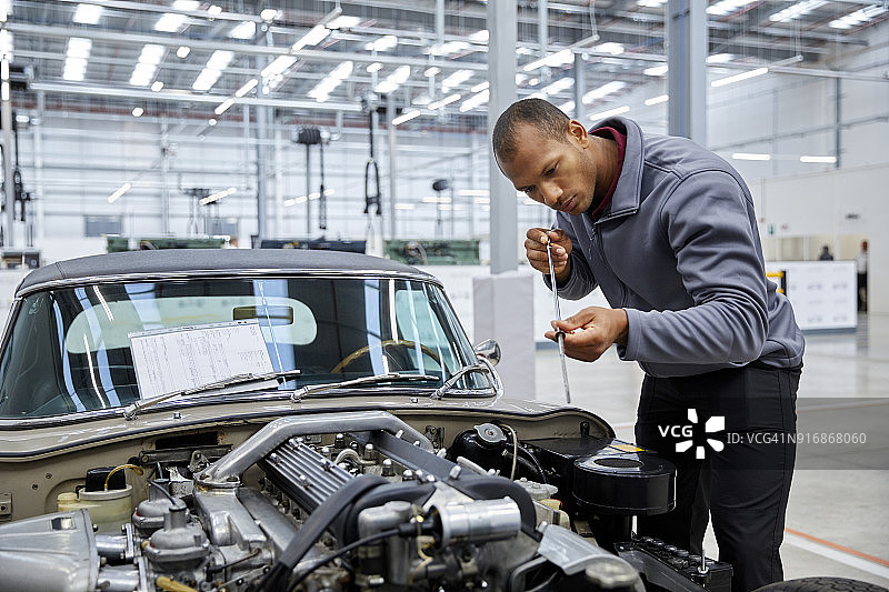 工程师用量油尺检查汽车机油图片素材