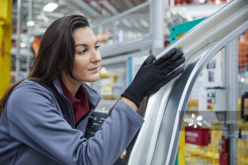 女维修工程师触摸汽车底盘图片素材