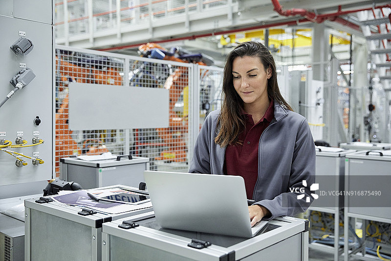 女主管在汽车工厂使用笔记本电脑图片素材