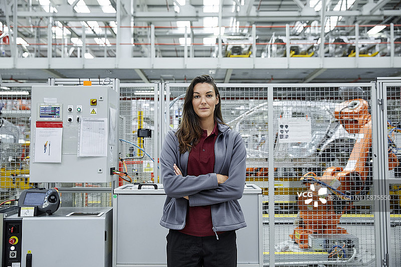 自信的女工程师站在汽车厂图片素材