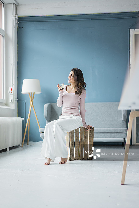 年轻女人阁楼里喝咖啡看向窗外图片素材