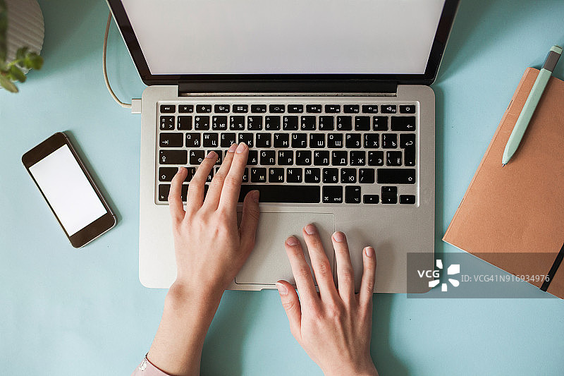 白人女人在桌旁使用笔记本电脑的高视角照片图片素材